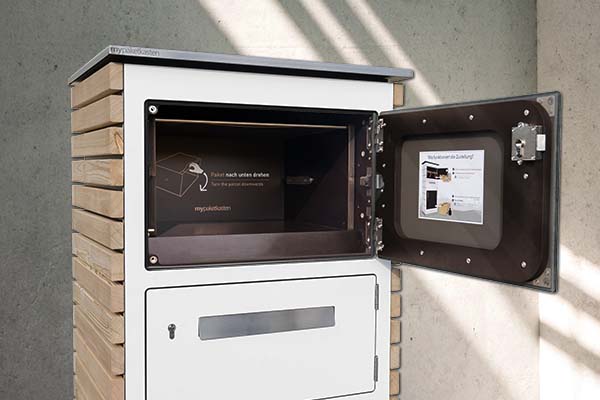 Grosser Paketkasten mit Drehkasten. Oberstes Fach vom Paketkasten steht offen. mypaketkaste Logo im Innenraum zu sehen.